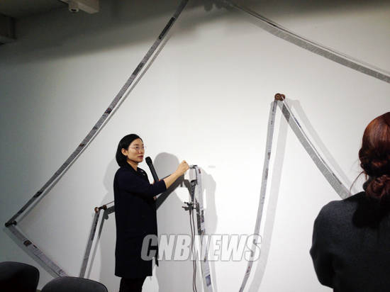 박혜수 작가가 23일 열린 기자간담회에서 ‘글루미 먼데이(Gloomy Monday)’를 연주하고 있다. 한국, 영국의 월요일 신문에서 부정적 단어가 쓰인 자리에 구멍을 뚫어 멜로디박스에서 연주될 수 있는 악보로 바꿨다. 사진 = 윤하나 기자