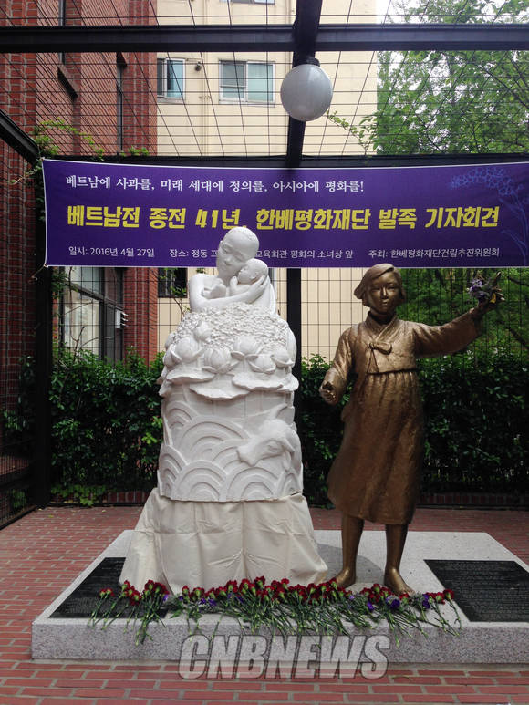 소녀상 옆에 나란히 자리한 '베트남 피에타' 상. 기자회견 이후 시민들이 헌화한 꽃들이 조각상 앞에 놓여 있다. (사진 = 윤하나 기자)