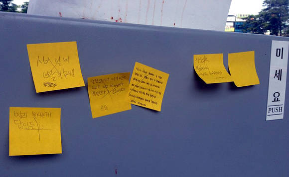 욕설이 곁들여진 포스트잇이 일부 붙어 있지만, 그 위에는 또 X 표시가 돼 있어 의견이 엇갈림을 보여주고 있다. 오른쪽으로 '미세요' 표지판도 보인다. (사진=윤하나 기자)