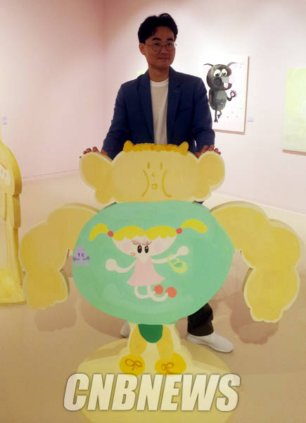 자신의 작품 사이에서 포즈를 취한 홍학순 작가.(사진=김금영 기자)